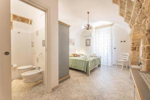 a bathroom with a toilet and a bed in a room at Appartamento Misya in Felline +20 photos