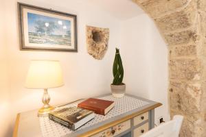 a table with a lamp and books and a plant on it at Appartamento Misya in Felline