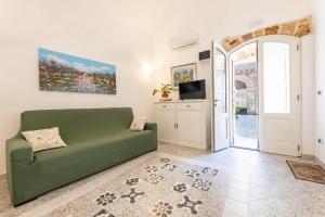 a living room with a green couch and a tv at Appartamento Misya in Felline