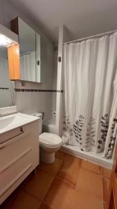 a bathroom with a toilet and a shower curtain at V.U.T. EL HONGO in Mora de Rubielos