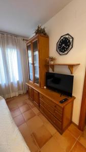 a bedroom with a tv on a wooden dresser at V.U.T. EL HONGO in Mora de Rubielos