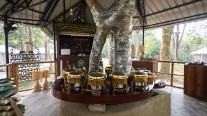 a statue of a man standing next to drums at Vaani Greens Wildlife Resort, Kaziranga in Kuthari