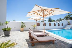 two chairs and an umbrella next to a swimming pool at Casa Evita in Gennadi