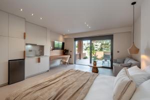 a bedroom with a large white bed and a kitchen at Villa Terra Rossa in Daratso