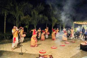 a group of people dancing around a fire at Vaani Greens Wildlife Resort, Kaziranga in Kuthari +87 photos
