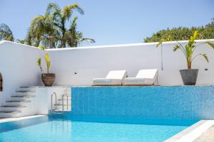 a swimming pool with two chairs next to a house at Casa Evita in Gennadi