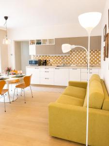 a living room with a yellow couch and a table at The Secret Lakeside in Gravedona