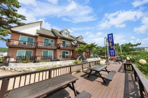 a building with two benches on a boardwalk at mongsanpo cueogpensyeon in Taean