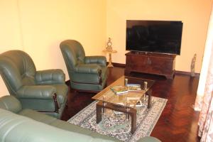 a living room with two leather chairs and a flat screen tv at A Casa de Santana in Santana