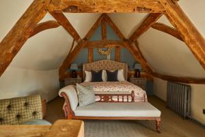 a bedroom with a bed and a chair in a attic at The Porch House in Stow on the Wold