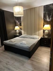 a bedroom with a bed with two night stands and two lamps at Wellness hotel Velky Meder in Veľký Meder +10 photos