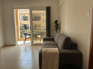 a living room with a couch and a sliding glass door at Horizon Court in Kiti