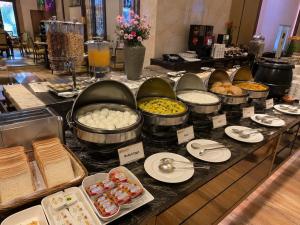a buffet with bowls and plates of food on a table at Hotel Smart Premier -Delhi Airport in Behror