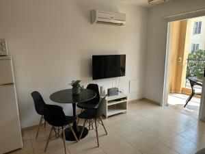 a living room with a table and a tv at Horizon Court in Kiti