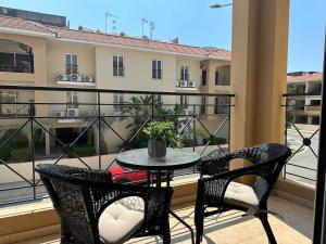 a table and two chairs on a balcony with a view of a building at Horizon Court in Kiti