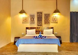 a bedroom with a bed with a blue flower on it at Ocean Breeze Boutique Hotel in Nungwi