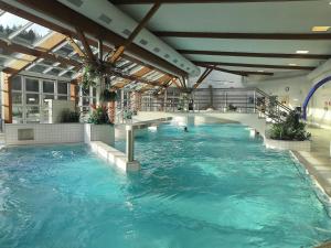 a swimming pool with blue water in a building at Ski&Bike apartmán INFFINITY in Janske Lazne