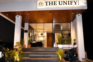 a lobby of a building with stairs and a sign at Hotel The Unify in Jāmb