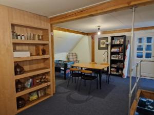 a dining room with a table and a book shelf at Vakantiewoning Blauhûs in Surhuisterveen