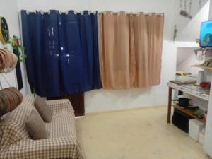 a living room with blue curtains and a couch at Chale Canoa Beach in Canoa Quebrada