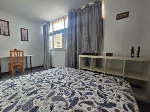 a bedroom with a bed and a desk and a window at Aguilon in Arrecife