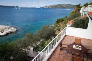 a balcony with a table and chairs and the water at Apartments Sundance in Okrug Donji
