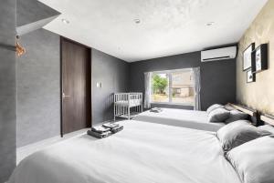 a bedroom with three large beds and a window at The Elements in Nakafurano +42 photos