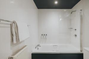 a white bathroom with a shower and a sink at Arthouse Glasgow - Newly Refurbished in Glasgow +54 photos