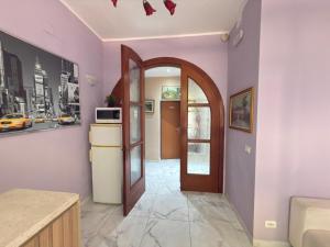 a hallway with a door and a kitchen with purple walls at Dream holiday in Mestre