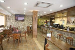 a restaurant with a bar and tables and chairs at O Cruceiro da Ulla in Vedra