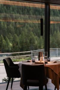 a dining table with two chairs and a large window at MyPARADIES in Solda