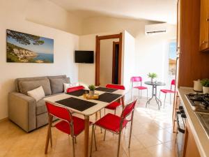 a kitchen and a living room with a table and chairs at Appartamento Eli in Valledoria