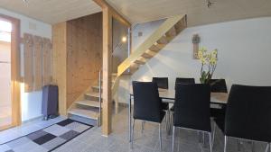 a dining room with a table and chairs and a staircase at Big 3-bedroom flat with new kitchen in Brienz +17 photos