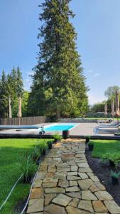 a swimming pool sitting in a yard next to a tree at Moho in Yablunytsya