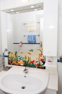 a mirror above a sink in a bathroom at Apartments Sundance in Okrug Donji +36 photos