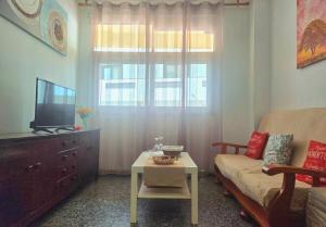a living room with a couch and a tv and a table at Aguilon in Arrecife +19 photos