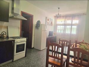 a kitchen with a white refrigerator and a table with chairs at Aguilon in Arrecife