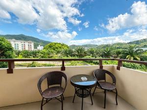 a balcony with two chairs and a table with a view at patong v hotel in Patong Beach