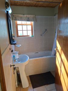 a bathroom with a sink and a bath tub at Rietfontein Guest Farm in Ladismith