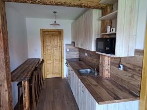 a kitchen with wooden cabinets and a wooden counter top at Drevenica Šumiac in Šumiac +4 photos
