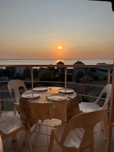 a table and chairs on a balcony with the sunset at Hotel Elion in Zatoka