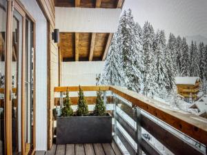 a balcony with a view of a snow covered forest at Crystal Lodge St Moritz in St. Moritz
