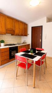a kitchen with a table and red chairs in it at Appartamento Eli in Valledoria