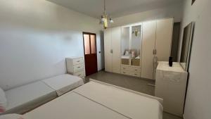 a white room with a bed and a mirror at Vacation Home Hoxha in Rrotull