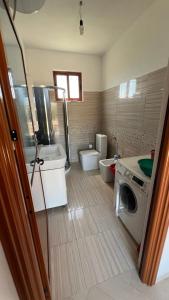 a bathroom with a sink and a washing machine at Vacation Home Hoxha in Rrotull +5 photos