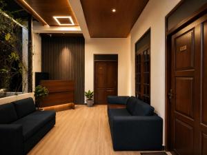 a living room with two blue couches and a door at Lava Ella in Ella