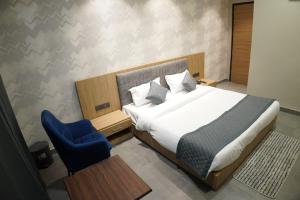 a bedroom with a bed and a blue chair at HOTEL CENTRAL PARK in Bathinda