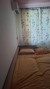 a bed in a room with a curtain and a window at Махамбета in Atyrau +1 photo