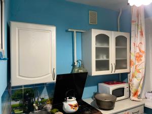 a small kitchen with a stove and a microwave at Махамбета in Atyrau