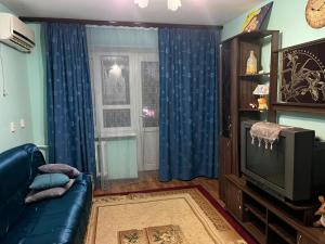 a living room with a couch and a television at Махамбета in Atyrau